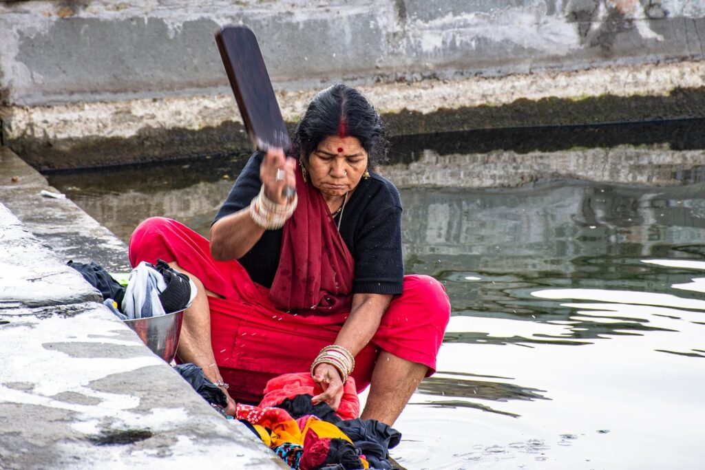 Uma senhora local lava as roupas na beira do Lago Pichola, uma tradição que permanece em Udaipur