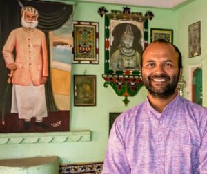 Vishal ao lado das imagens de seus ancestrais em sala que relembra a história da família